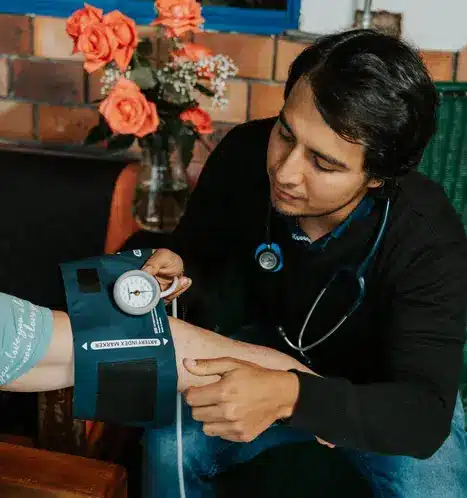 Kevin Zapata MD checking the blood pressure of a patient at Harmonica Retreat
