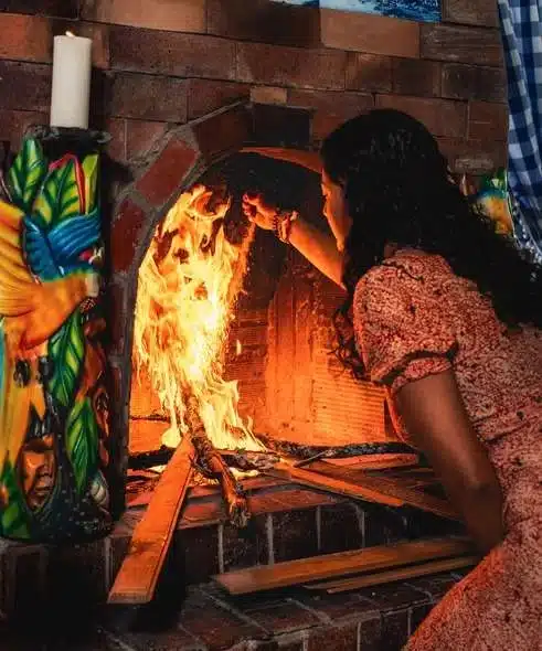 Female facilitator Jenna tending to the fire in a Harmonica Retreat ceremony