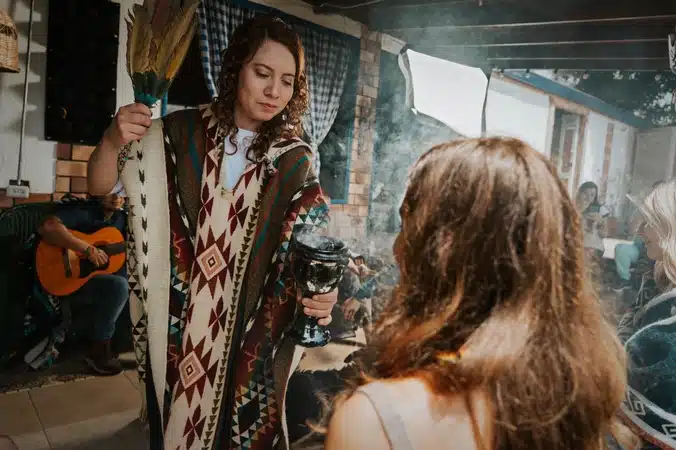 Female facilitator cleaning a participant with incense