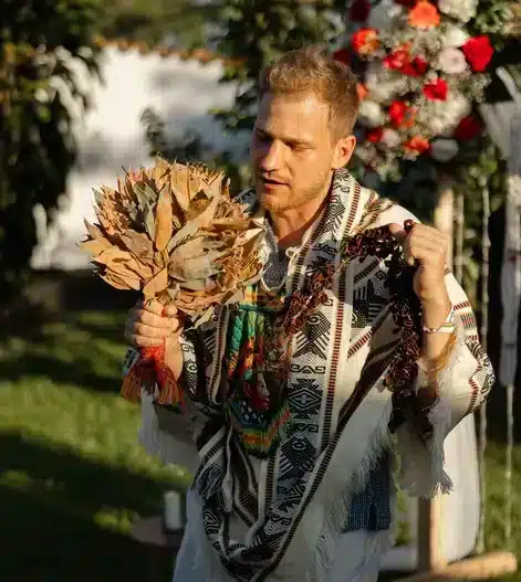 Oliver from Harmonica retreat in a ceremony saying a prayer and using the Waira and Cascavelles