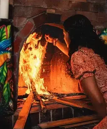 Female facilitator Jenna tending to the fire in a Harmonica Retreat Ayahuasca ceremony