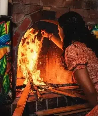 Female facilitator Jenna tending to the fire in a Harmonica Retreat Ayahuasca ceremony