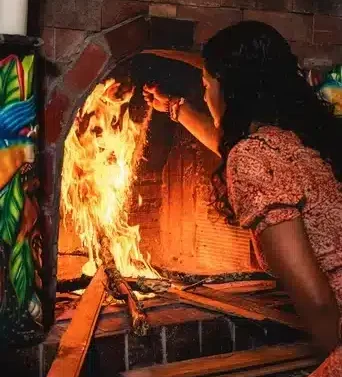 Female facilitator Jenna tending to the fire in a Harmonica Retreat Ayahuasca ceremony