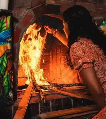 Female facilitator Jenna tending to the fire in a Harmonica Retreat Ayahuasca ceremony