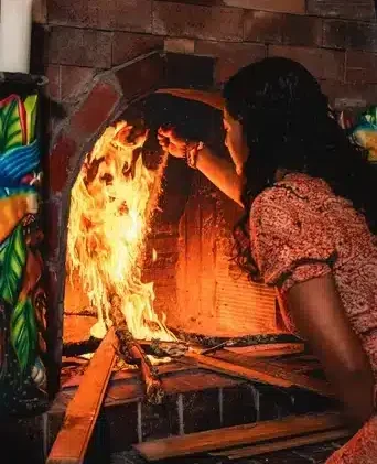Female facilitator Jenna tending to the fire in a Harmonica Retreat Ayahuasca ceremony