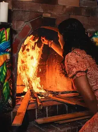 Female facilitator Jenna tending to the fire in a Harmonica Retreat Ayahuasca ceremony