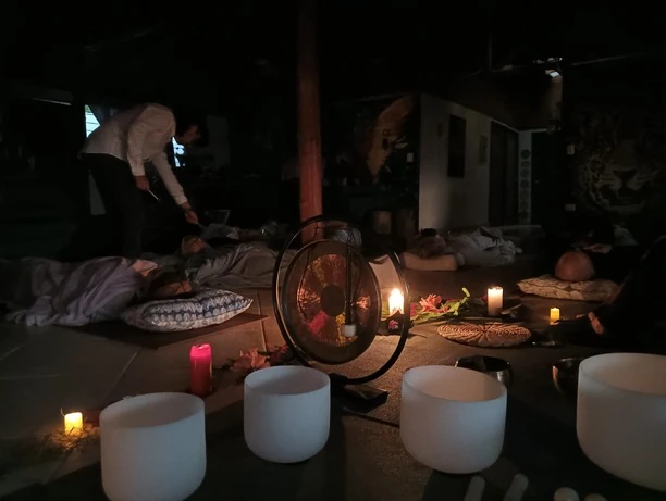 Crystal singing bowls and candles around a resting circle during a sound healing ceremony
