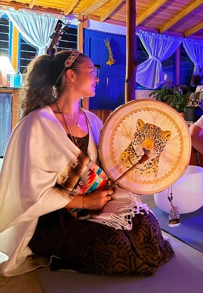 Facilitator holding a jaguar frame drum during a sound healing ceremony at Harmonica Retreat