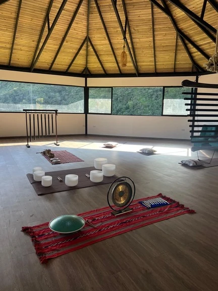 Singing bowls, gong and chimes laid out on the maloka floor before a sound healing session