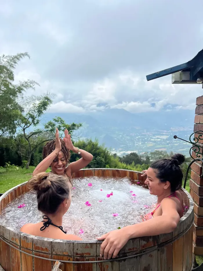 Two women raising their arms in the ice bath