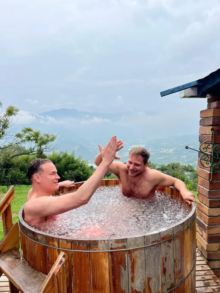 Two men high-fiving in the ice bath