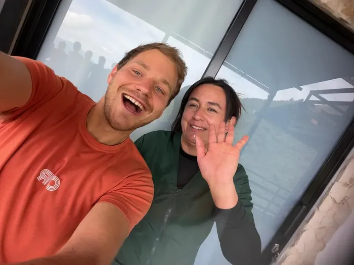 Oliver and Diana smiling and waving hello in a selfie