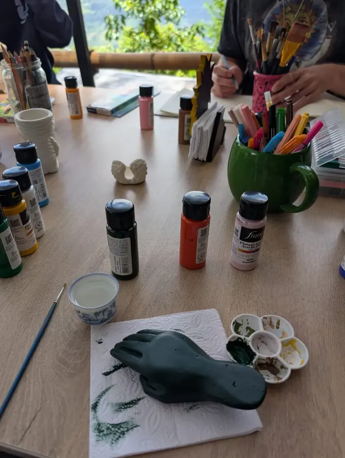 Paints, brushes and a clay figure on the table during an art session